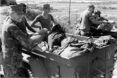 Captain Stolz inspecting captured enemy gear after a fight and a shower RVN.